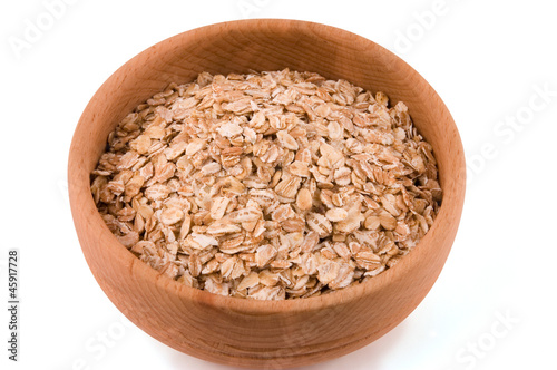 A bowl of oat flakes on white