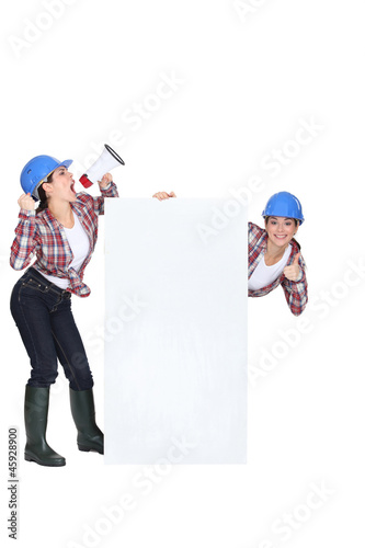 Female builder with poster and megaphone © auremar