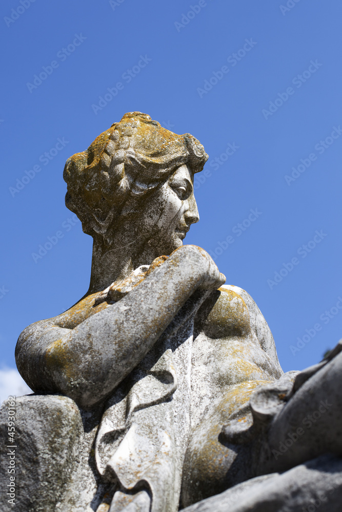 old statue against blue sky