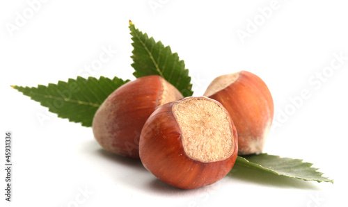 tasty hazelnuts with leaves, isolated on white