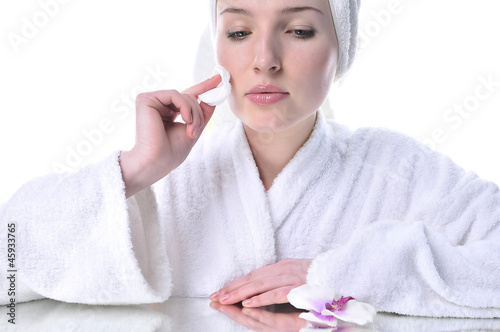 Beautiful woman in a white dressing gown cleaning your face