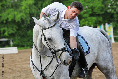 Jockey seat on horse feed from hand on hippodrome