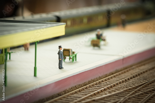 well dress miniature figure waiting for a model train