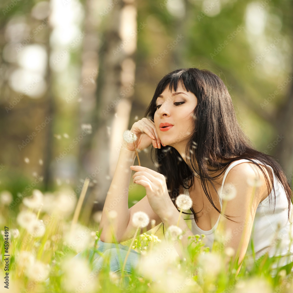 Cute woman in the park with dandelions Cute woman in the park with dandelions