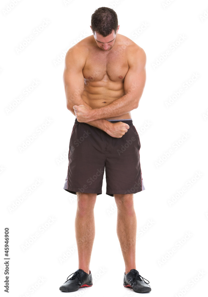 Full length portrait of muscular sportsman showing muscles