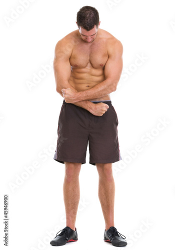 Full length portrait of muscular sportsman showing muscles © Alliance