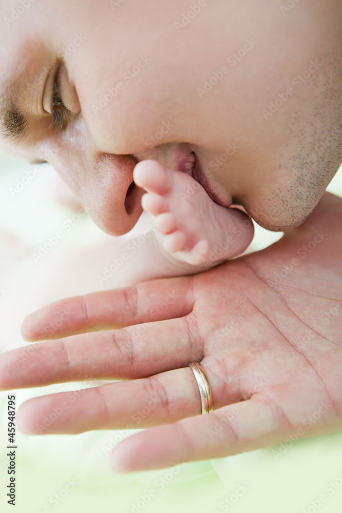 Close up of the father of baby kissing a leg