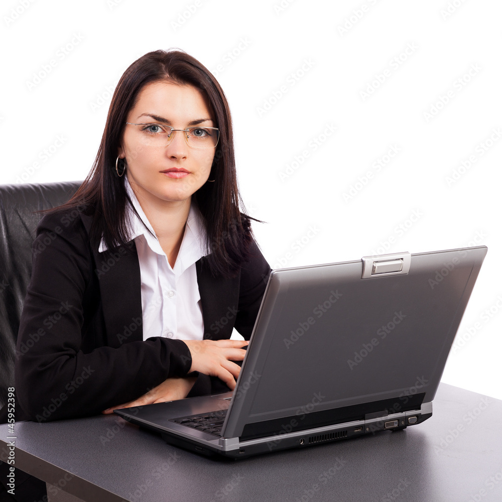 Serious young businesswoman sitting at office desk Serious young businesswoman sitting at office desk