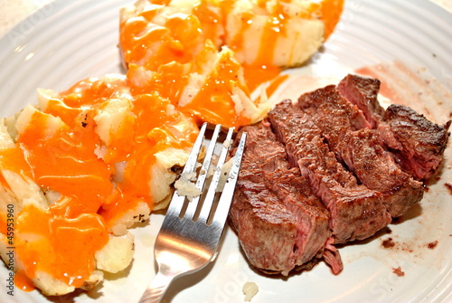 Sliced Filet Mignon with French Dressing Over a Potato photo