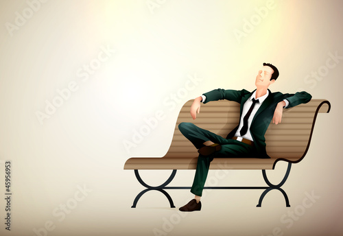 Young business man taking a relaxing break on a bench