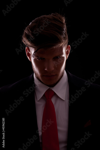 elegant young business man posing in darkness photo