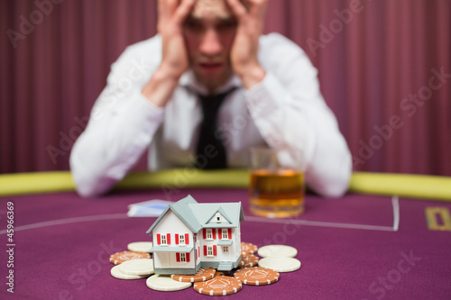 Obraz na płótnie Man is betting his house at poker game