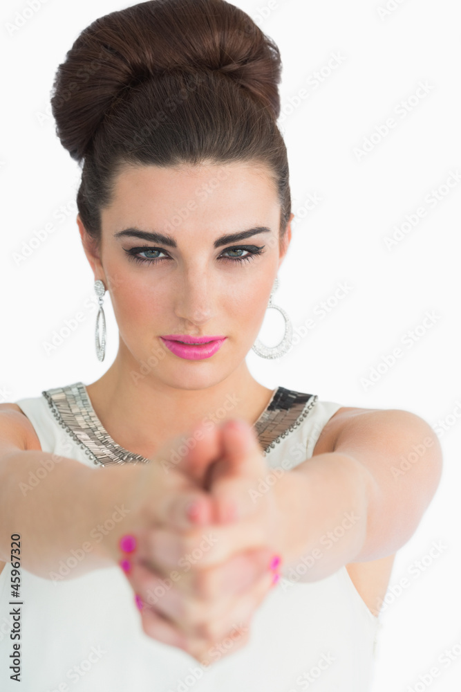 Woman forming a pistol with her hands and pointing at the camera