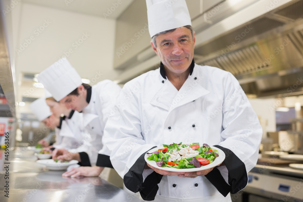 Cheerful chef presenting his salad Cheerful chef presenting his salad