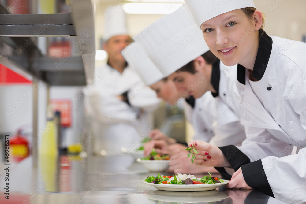 Happy chef looking up from preparing salad Happy chef looking up from preparing salad