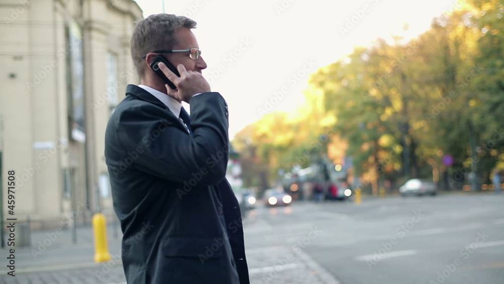Businessman talking on cellphone in the city, steadicam shot