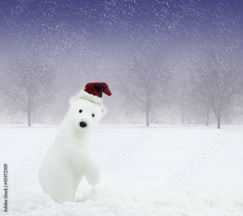 White bear with Santa Claus hat in snowy field
