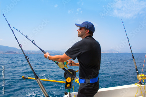 blue sea fisherman in trolling boat with downrigger