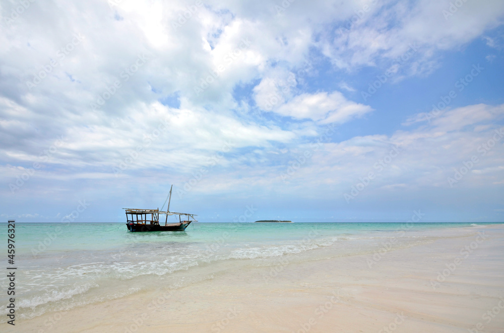 White Sandy beach with boat and Island with Blue Sky