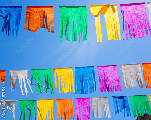 colorful tissue Paper fringe garland under blue sky photo