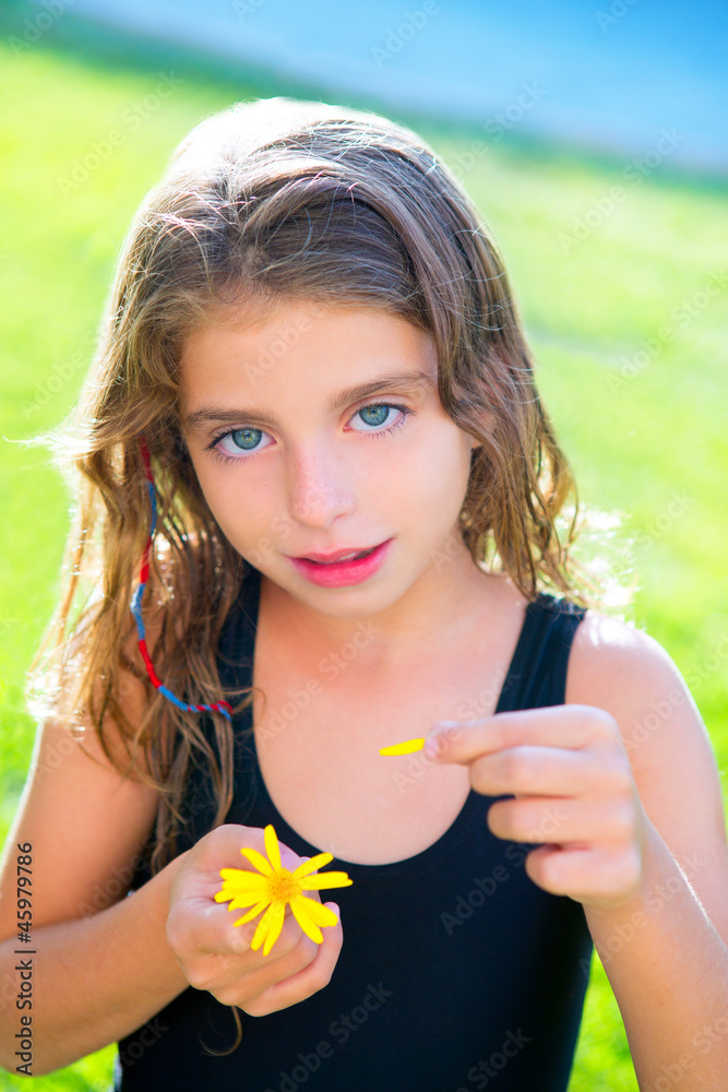 children girl testing love with yellow daisy flower petals children girl testing love with yellow daisy flower petals
