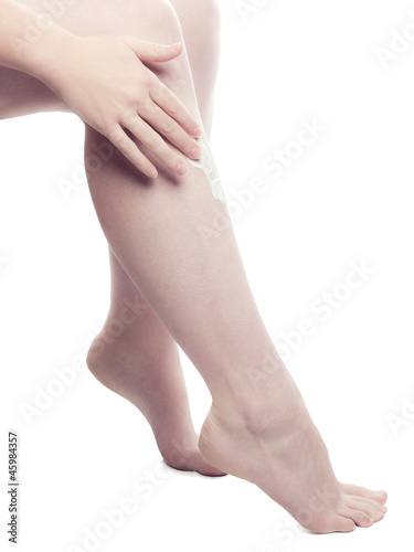 Woman Putting Cream On Her Leg - isolated © stockfotografie.net