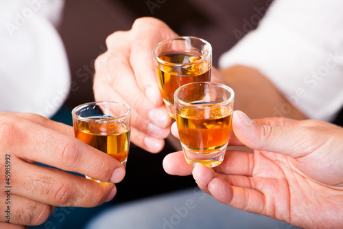 Männer beim Anstoßen mit Rum