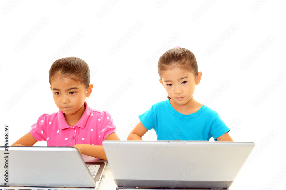 パソコンを楽しむ笑顔の姉妹