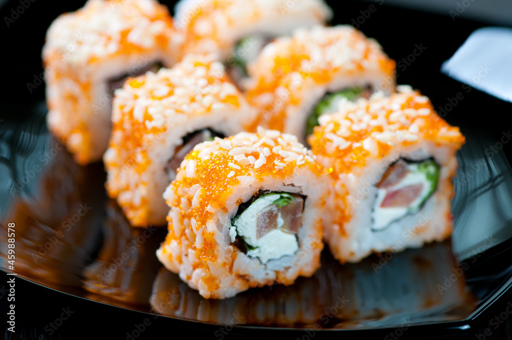 Geisha rolls on a black plate, horizontal shot, close-up Geisha rolls on a black plate, horizontal shot, close-up