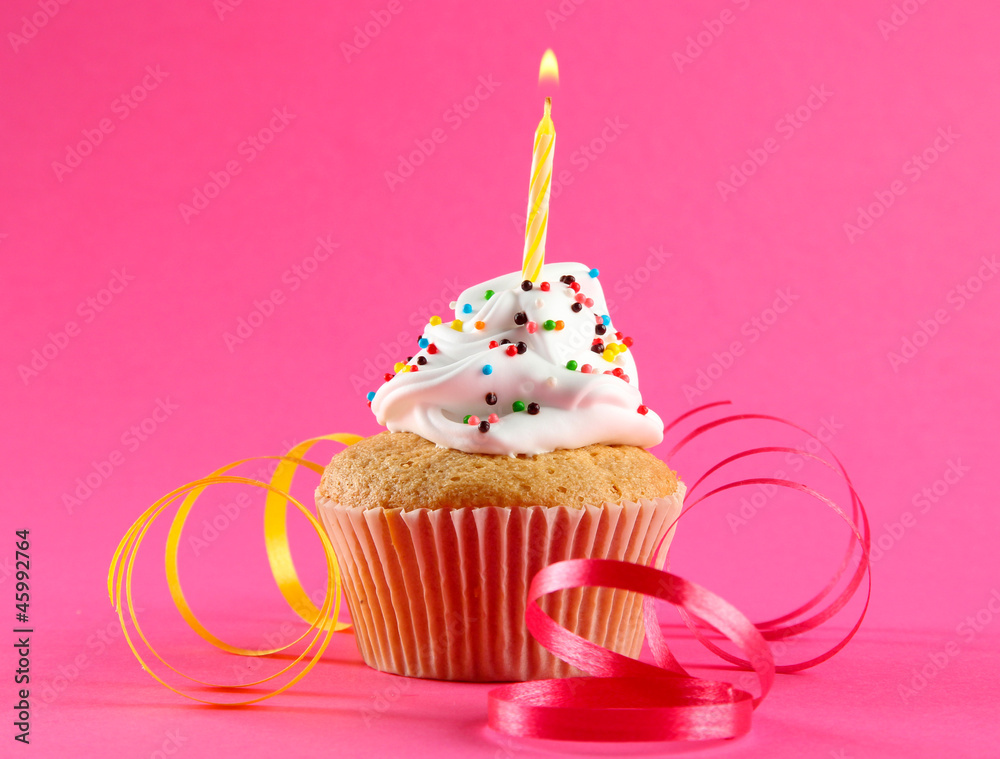 tasty birthday cupcake with candle, on pink background