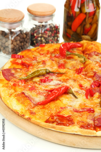 Tasty pepperoni pizza with vegetables on wooden board close-up