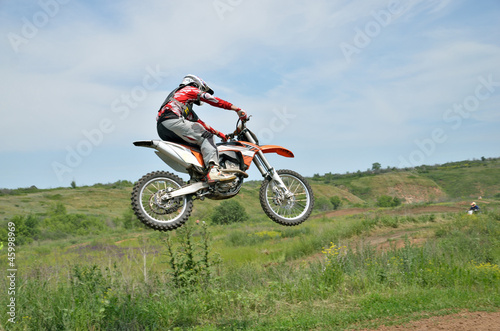 Motocross rider on a motorcycle in a jump