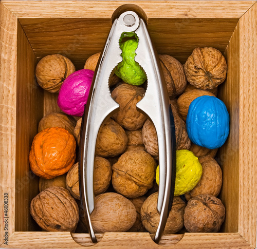 Walnuts in a wooden box with metal nippers