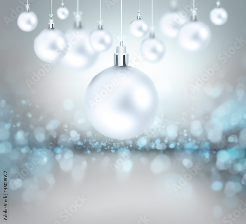 Christmas balls hanging with ribbons on abstract background