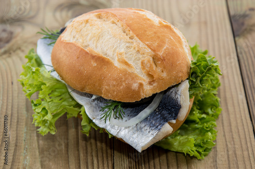 Fresh Herring on a roll (wooden background)