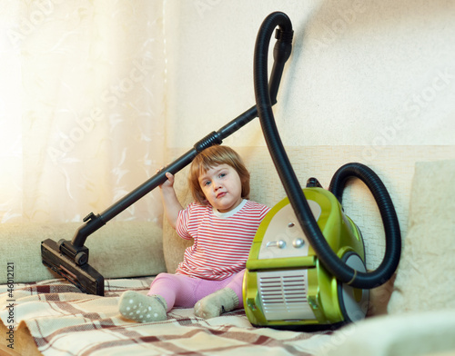 Baby girl with vacuum cleaner photo