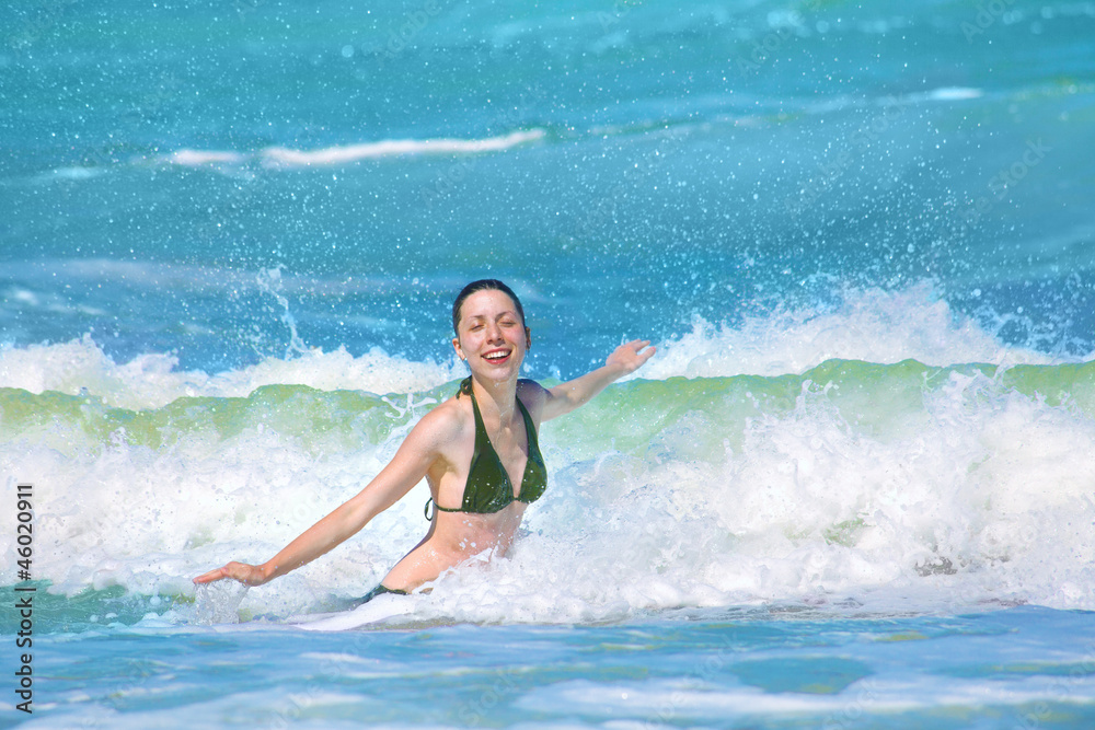 Happy girl splashing in the waves