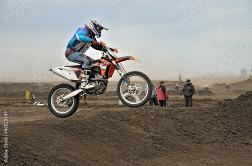 The motocross racer jumps by motorcycle