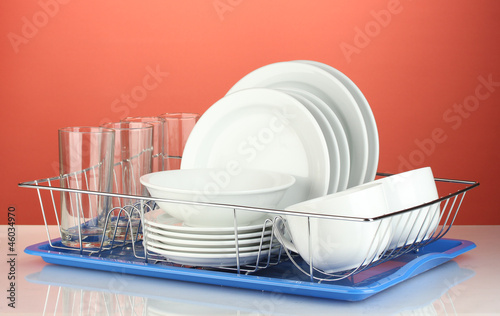 clean dishes on stand on red background