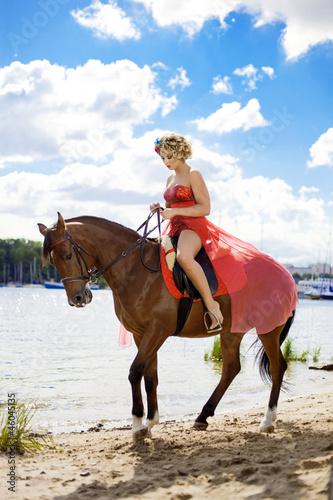 Woman with bright makeup on the horse outdoors
