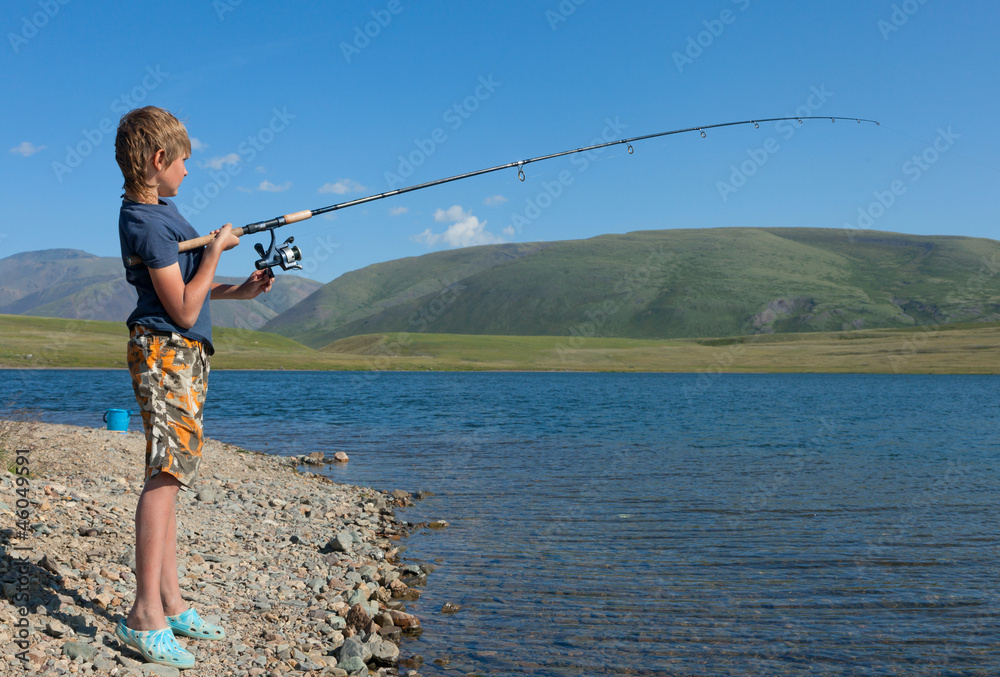 The boy with a spinning catch grayling The boy with a spinning catch grayling