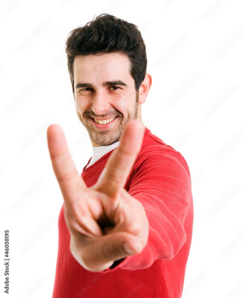 Smiling young man winner gesture against a white background Smiling young man winner gesture against a white background