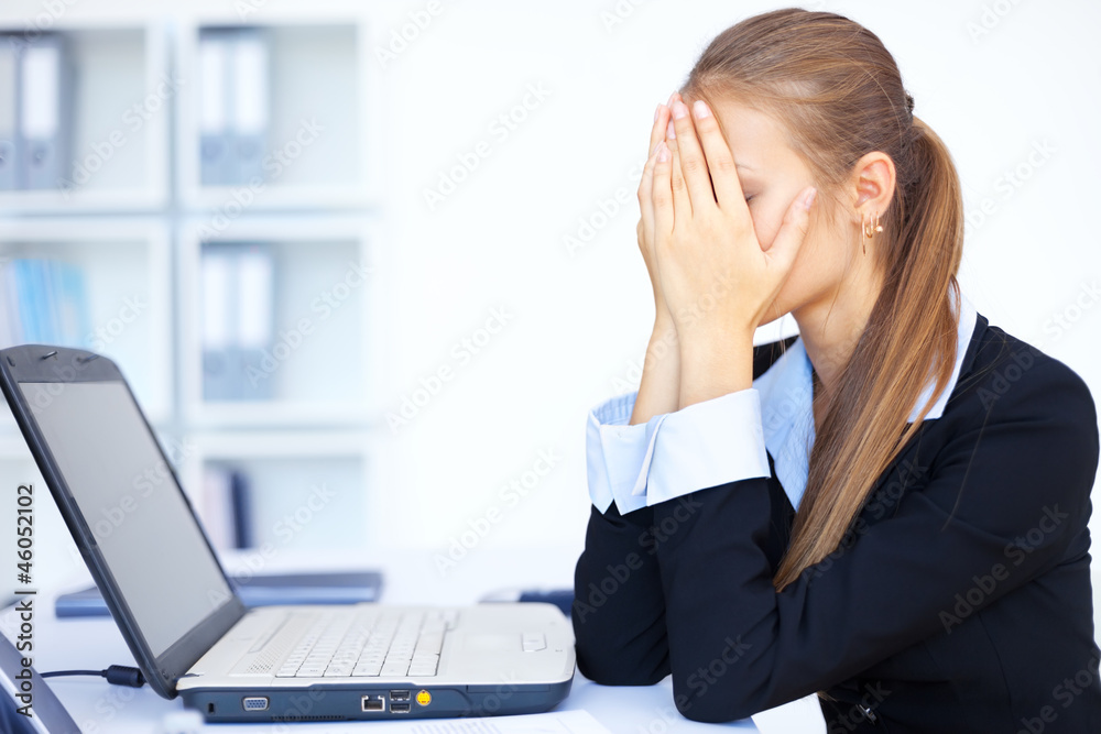 Portrait of tired young business woman with laptop computer Portrait of tired young business woman with laptop computer