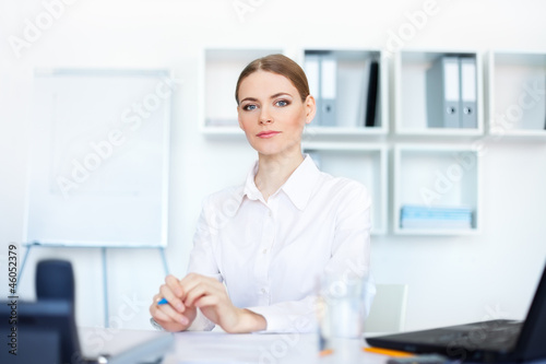 Portrait of beautiful young business woman sitting at desk