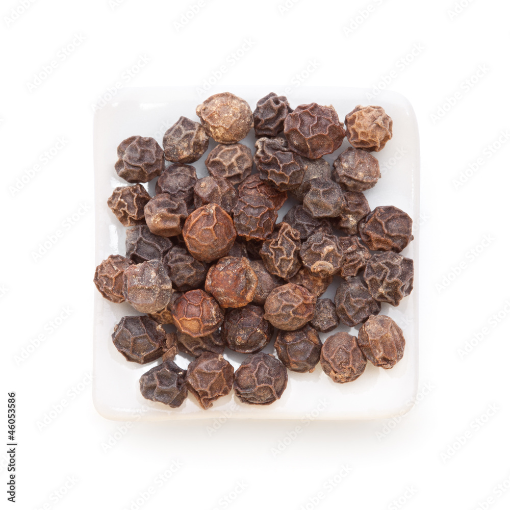 Black pepper (Piper nigrum) in a white bowl on white background. Black pepper (Piper nigrum) in a white bowl on white background.