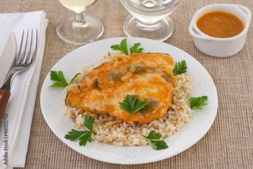 swordfish with olives, rice and parsley on the plate