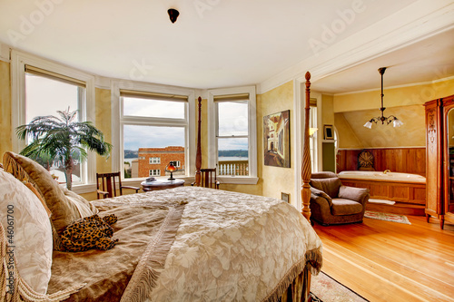 Large historical Inn room interior - bedroom with antique bed.
