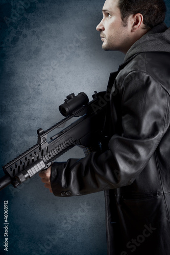 Man with long leather jacket and assault rifle