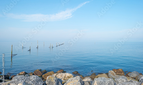 Dike along a lake at fall in mist