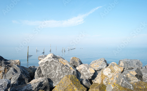 Dike along a lake at fall in mist